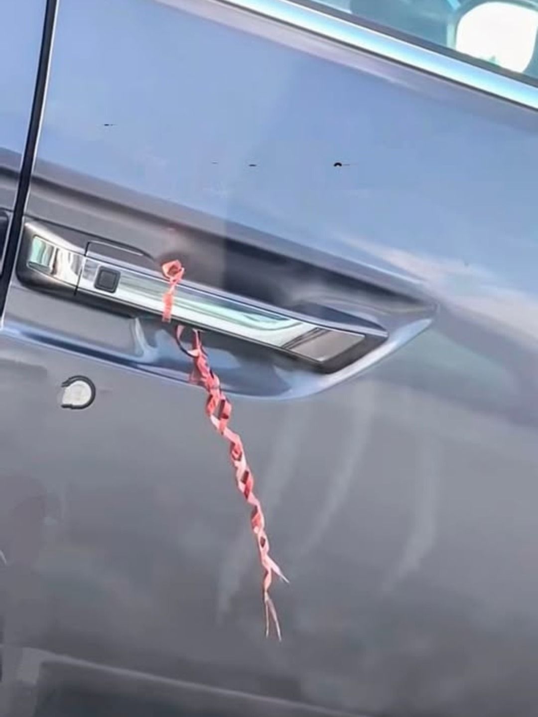Ich war in einem Laden in der Nähe einkaufen und als ich zu meinem Auto zurückkam, bemerkte ich etwas Seltsames. An dem Türgriff war eine Schnur oder ein Band befestigt.